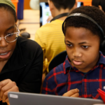 Volunteer working with student on Hour of Code